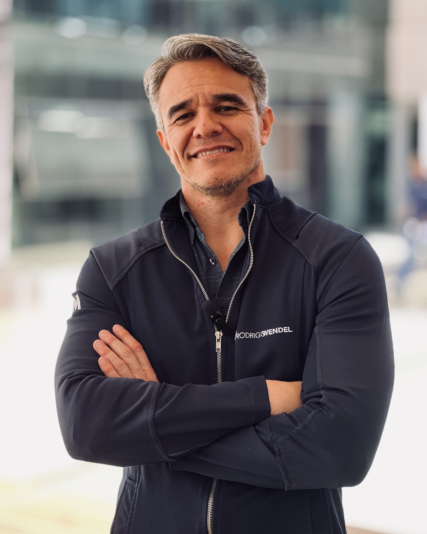Dr. Rodrigo Wendel de braços cruzados, com jaqueta escura, em ambiente urbano